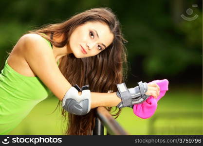 Happy young girl enjoying roller skating rollerblading on inline skates sport in park. Woman in outdoor activities