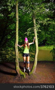 Happy young girl enjoying roller skating rollerblading on inline skates sport in park. Woman in outdoor activities