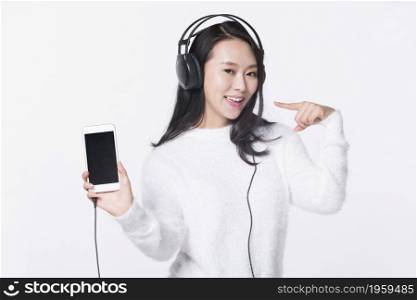 Happy young girl listening to music on her mobile phone