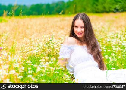 happy young girl lying in a field with daisies