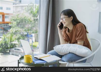 Happy young girl talking on the phone at home, making answering call, having pleasant conversation chatting by mobile with friend .