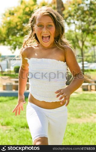 Happy young girl with wide open mouth running towards camera