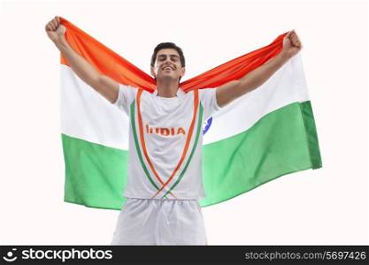 Happy young hockey player celebrating victory with Indian flag against white background