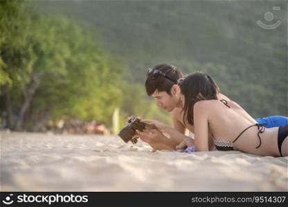 Happy young honeymoon couple on beach having vacation fun at paradise tropical island beach on sunny day. Young couple relax on white sand beach. Couple in love valentine honeymoon travel concept.