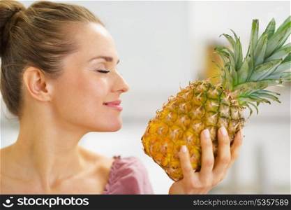 Happy young housewife enjoying fresh pineapple