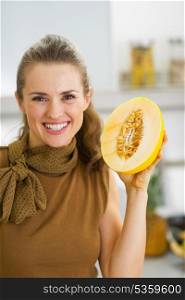 Happy young housewife holding melon slice
