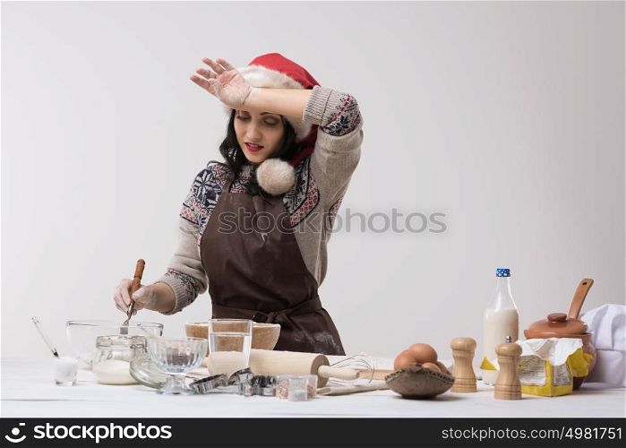 Happy young housewife making christmas cookies in kitchen