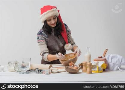 Happy young housewife making christmas cookies in kitchen