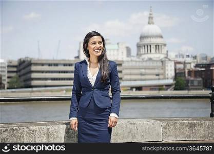 Happy young Indian businesswoman with St. Paul&acute;s Cathedral in background