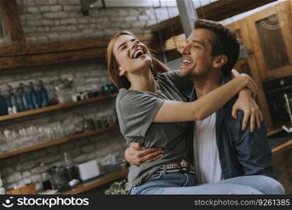 Happy young lovely couple in the rustic kitchen hugging each other