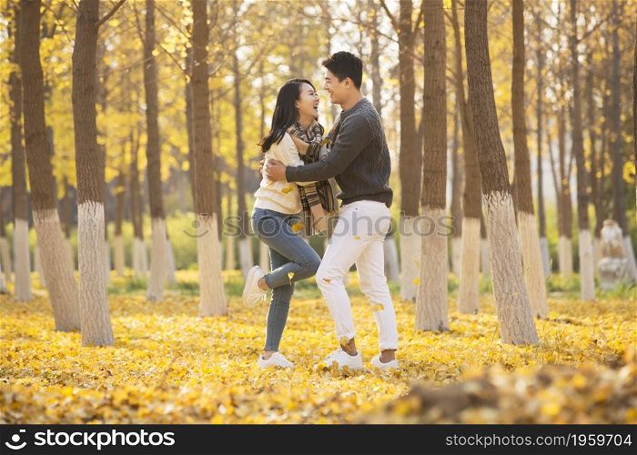 Happy young lovers frolicking in the woods