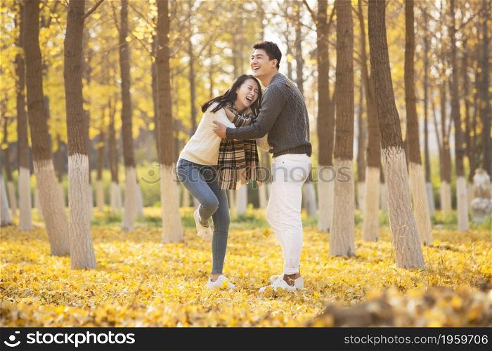 Happy young lovers frolicking in the woods