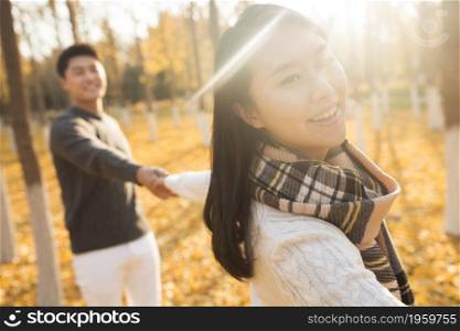 Happy young lovers walking in the woods