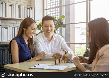 Happy young loving couple talking to their real estate agent with smile looking at house , Planning for the future of the family concept