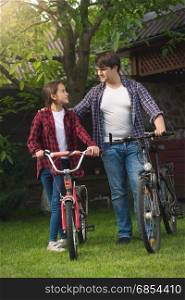 Happy young man and smiling girl posing with bicycles