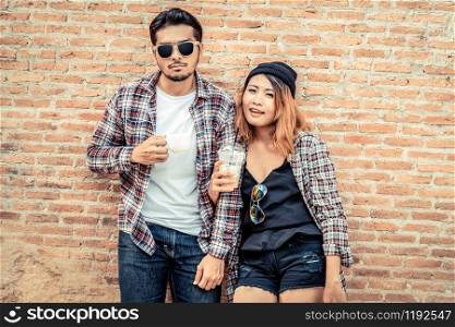 Happy young man and woman drink coffee at the town street. Couple and young people lifestyle.