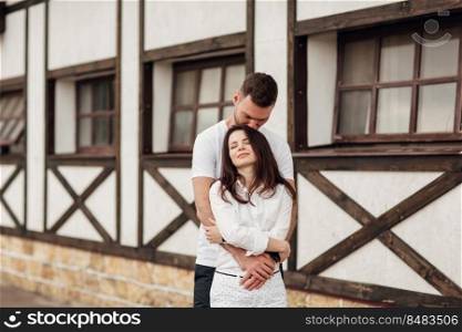 happy young man and woman having fun outdoors on a warm summer day. couple is hugging near horse rancho.. happy young man and woman having fun outdoors on a warm summer day. couple is hugging near horse rancho