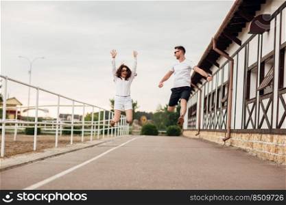 happy young man and woman jumping and having fun outdoors on a warm summer day. horse rancho.. happy young man and woman jumping and having fun outdoors on a warm summer day. horse rancho