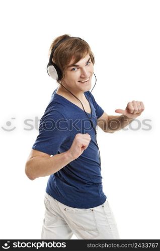 Happy young man dancing and listening music with headphones, isolated on white background