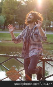 Happy young man dancing and listening to the music at the park.