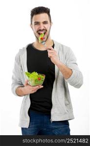 Happy young man eating a salad, isolated on white background