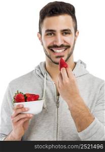Happy young man eating a strawberry, isolated on white background