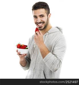 Happy young man eating a strawberry, isolated on white background