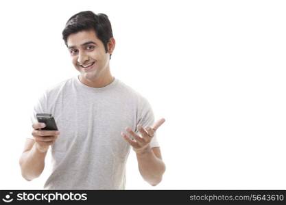 Happy young man gesturing while holding cell phone
