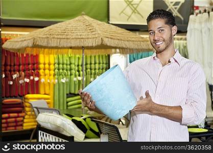 Happy young man holding a souvenir in store