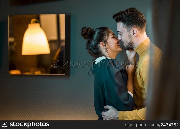 happy young man hugging cheerful woman room