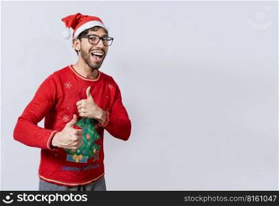 Happy young man in christmas hat giving thumbs up. People in santa hat doing ok gesture. Concept of christmas man giving thumbs up, Smiling guy in christmas hat with thumbs up
