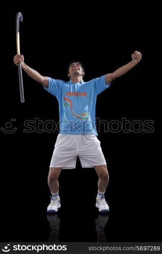 Happy young man in sportswear celebrating victory isolated over black background