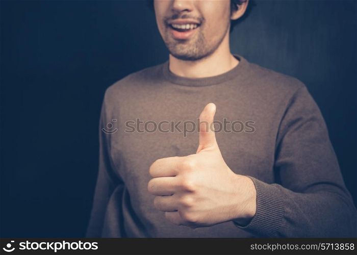 Happy young man is giving one thumb up
