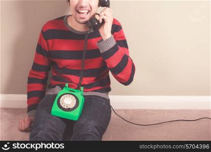 Happy young man is talking on the telephone