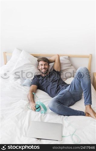 happy young man listening music bed
