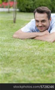 Happy young man lying on grass in park