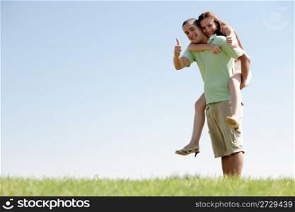 Happy Young Man Piggybacking His Girlfriend