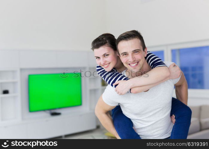 happy young man piggybacking his girlfriend at home