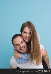 happy young man piggybacking his girlfriend isolated on blue background