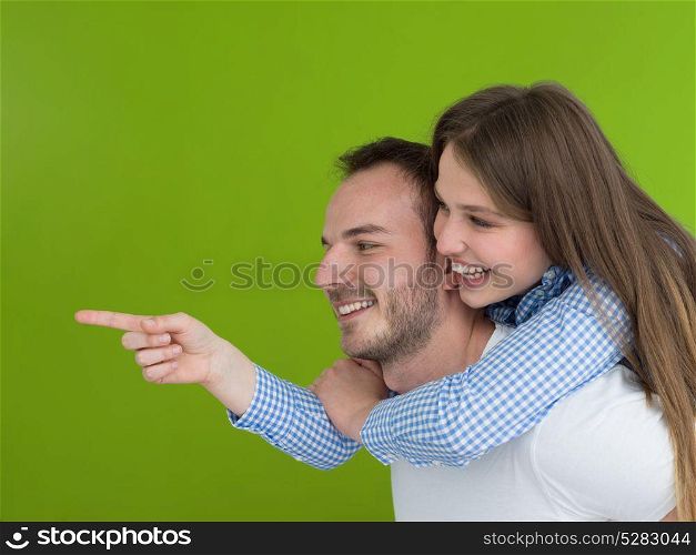 happy young man piggybacking his girlfriend isolated on green background