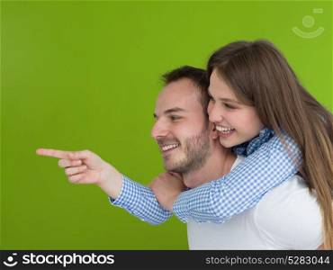 happy young man piggybacking his girlfriend isolated on green background