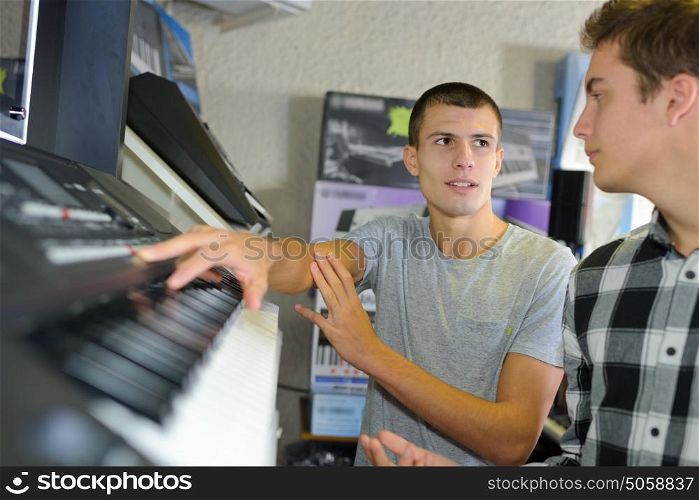 happy young man trying a piano at music store