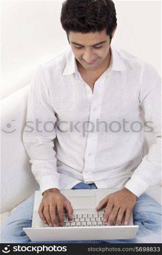 Happy young man using laptop