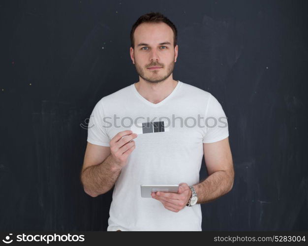 Happy young man using tablet computer isolated over gray background