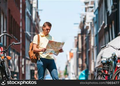 Happy young man with a city map in Europe. Happy young man with a city map in european city