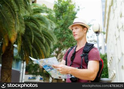 Happy young man with a map. I like new cities
