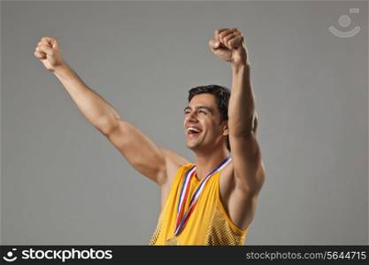 Happy young man with arms raised celebrating victory isolated over white background
