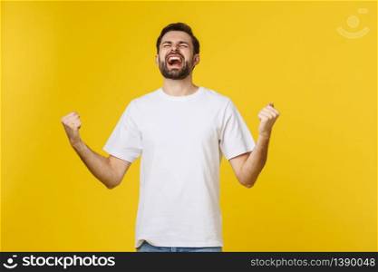 Happy young man with arms up isolated on a yellow background. Happy young man with arms up isolated on a yellow background.