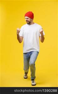 Happy young man with arms up isolated on a yellow background. Happy young man with arms up isolated on a yellow background.
