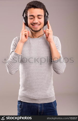 Happy young man with headphones on and listening to music